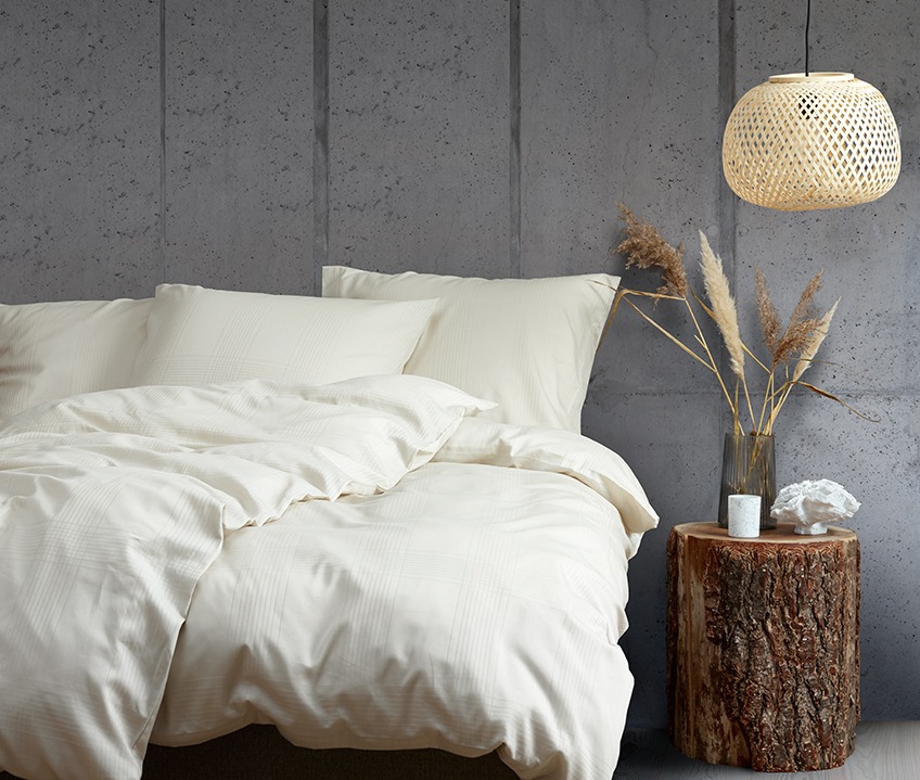 Elegant bedroom with a calm Nordic look and bed made with sand coloured bedding 