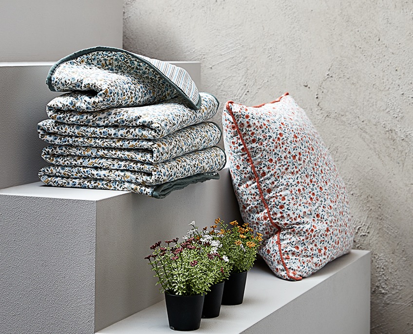 Staircase with floral throws and a cushion and three faux flowers