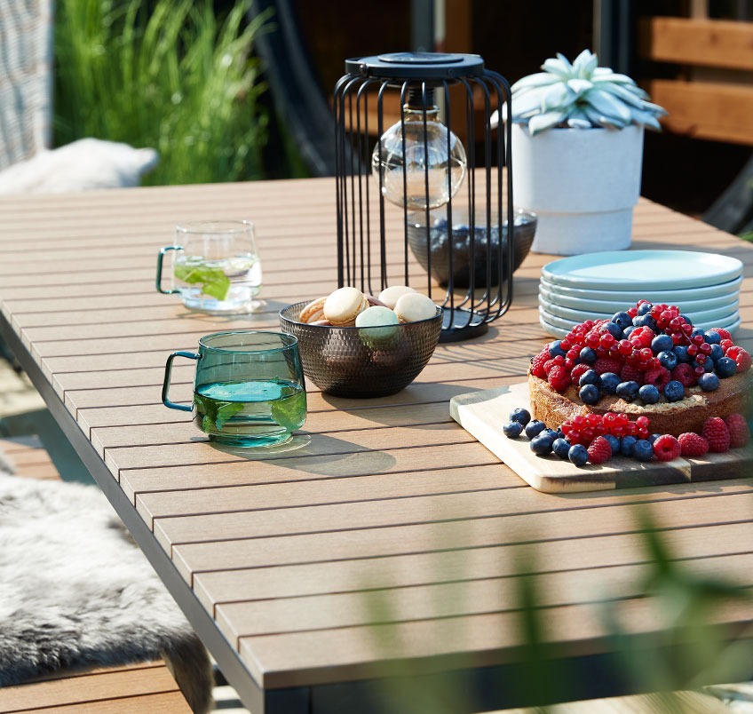 Garden table with cookies, cake and mugs 