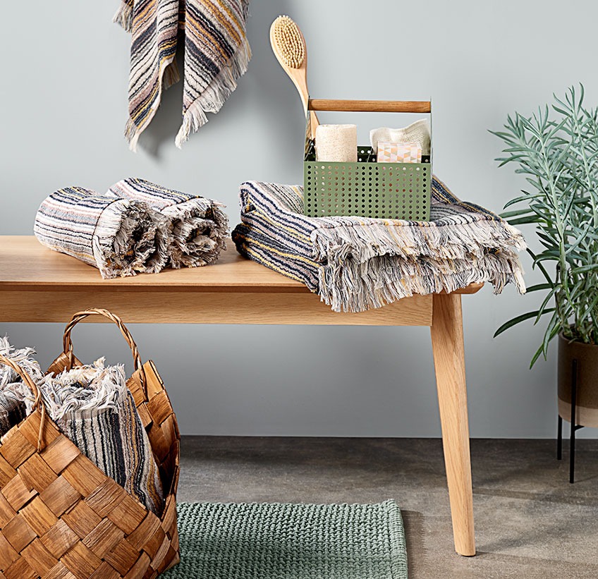 Cotton towels and other bathroom accessories on a bench  