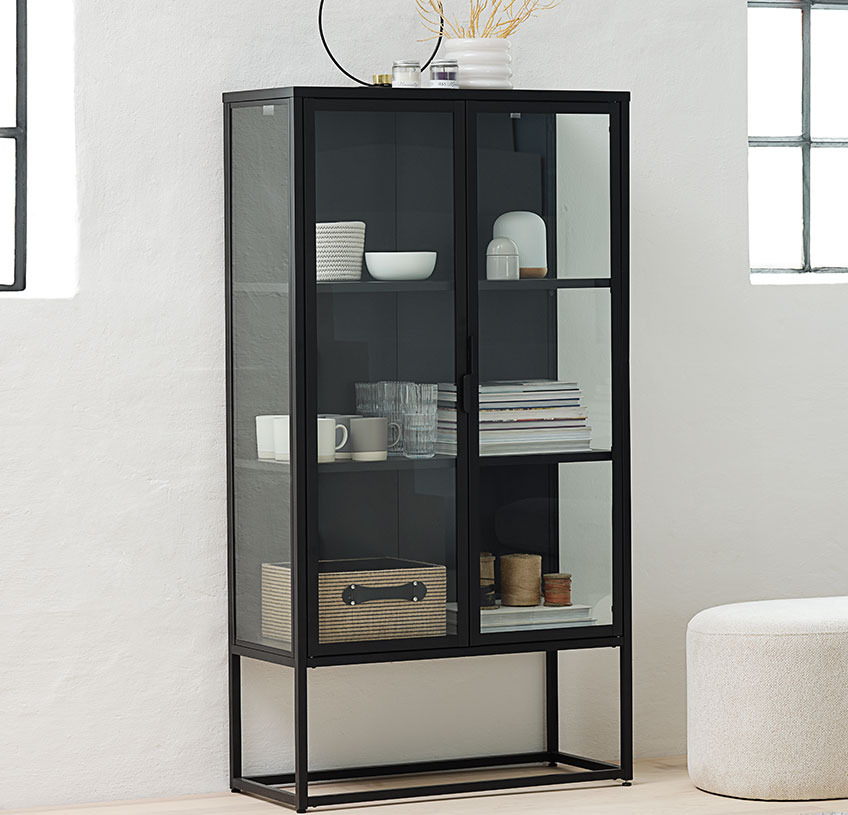Black cabinet with glass doors and sides in a light room 