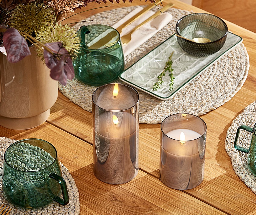 KLAUS LED candles, TETTEGRAS place mats, JONAS glass bowl, INGVART serving platter and ANDERS mugs Dinner table with wicker placemats, glass bowls and mugs