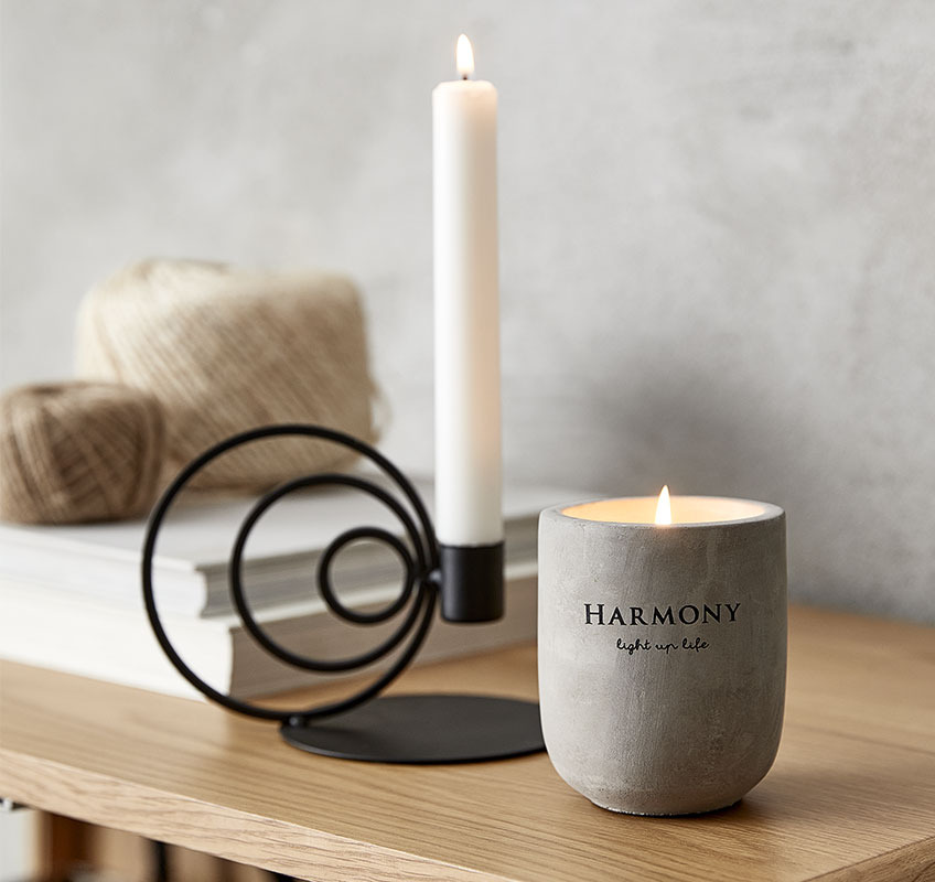 Black candlestick in sound shapes and rustic, grey candle