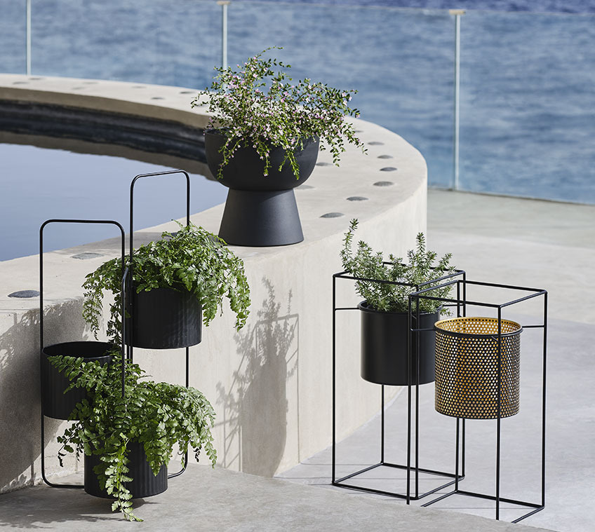 AND planter with three pots, black LOMVI planter and MIDSOMMER planter, available in black or gold colour Raised planters on a large balcony