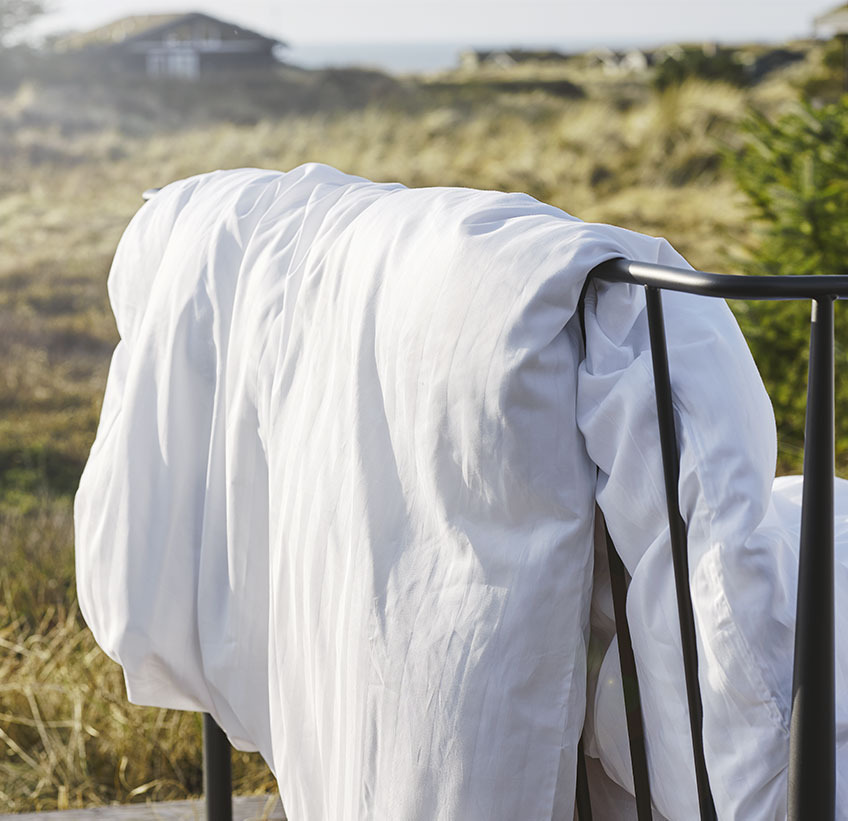 Duvet hanging over a fence in a natural setting 