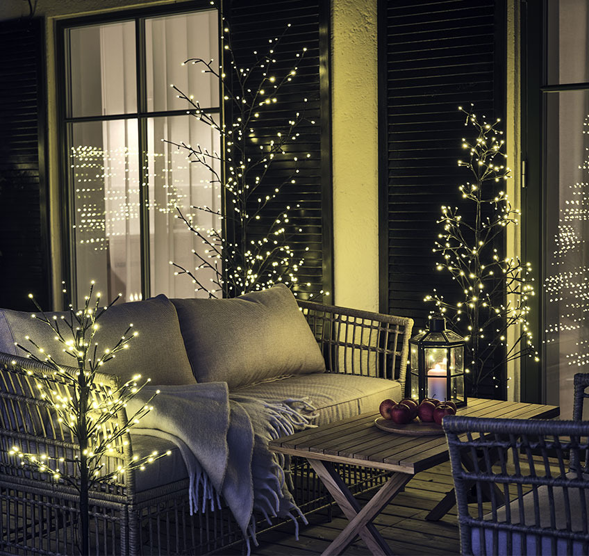 Outdoor light trees on a wooden patio with lounge set