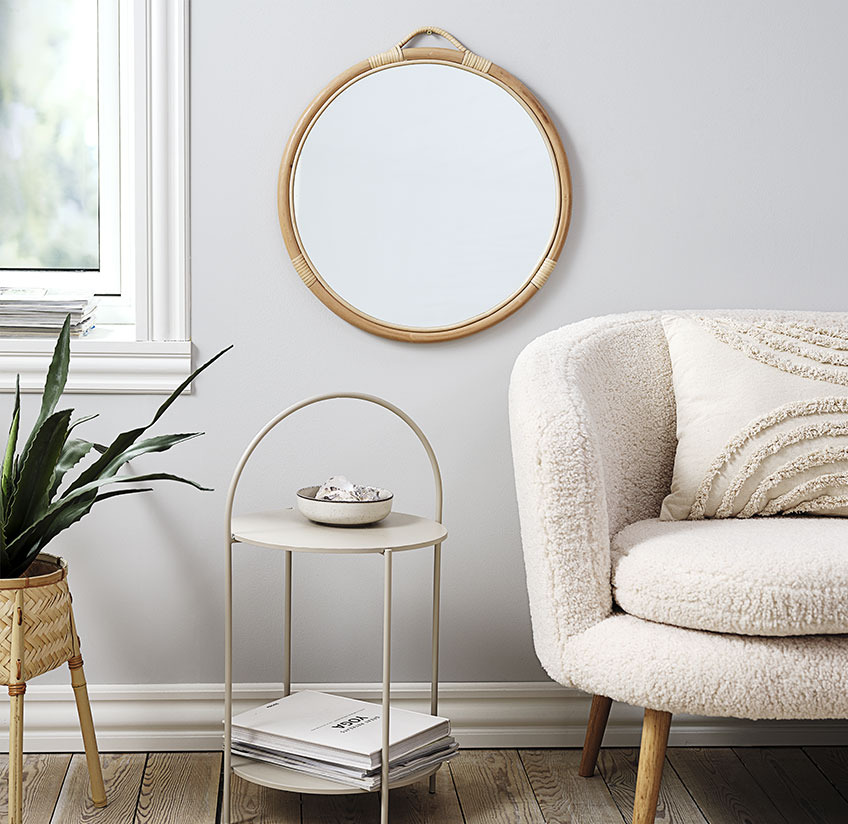 REFLECT mirror with a rattan frame above HALBY end table Round mirror above an end table