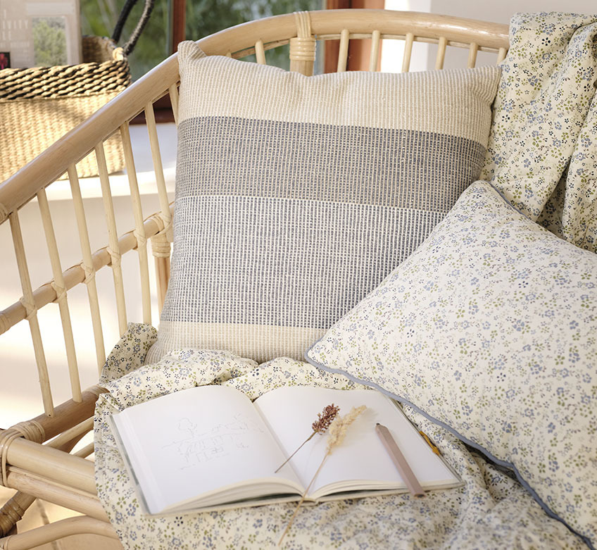 Sofa with quilted blanket and floral cushions