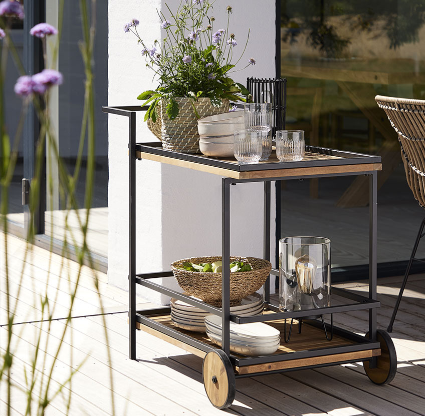 Trolley with plates and glasses on a patio