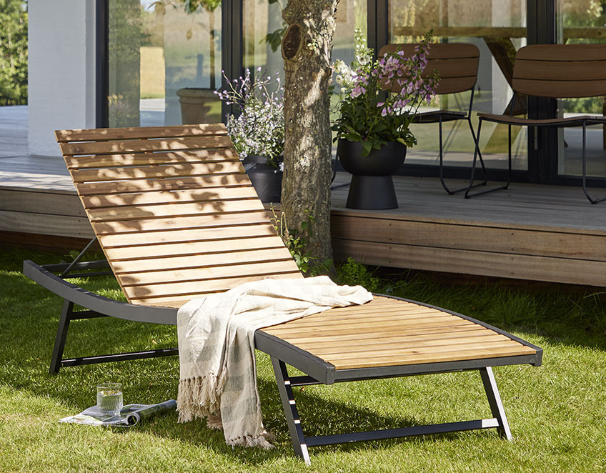 Sun lounger in wood and metal on a lawn