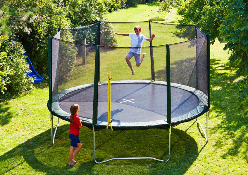 Children having fun on a trampoline in a summery garden