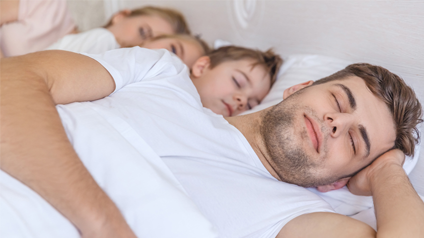 Family sleeping in bed